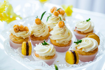very nice sweet table with yellow macaroons and white cupcakes