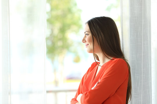 Thoughtful woman looking through window