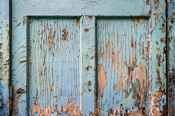 Fragment of old wooden door with peeling blue paint