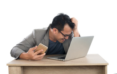 Stressed businessman work  with laptop sitting at table isolated