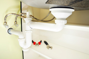 installing a drain for a kitchen sink close up. fixing the sink siphon in a kitchen