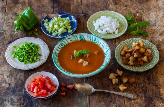 Spanish gazpacho with ingredients on plates