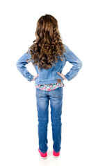 Portrait of adorable little girl in jeans standing back