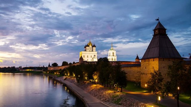Pskov Kremlin at sunset. Time-lapse of a colorful sky over a river and promenade area