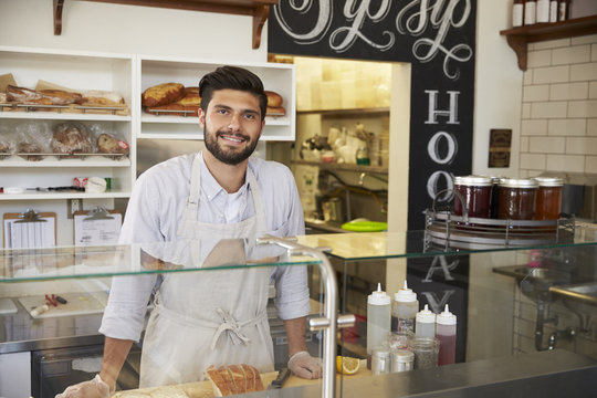 Small business owner behind the counter of a sandwich bar