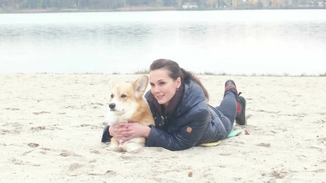 girl with a dog on the beach posing for a photograph