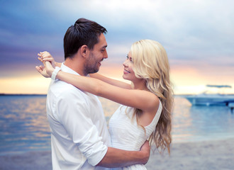 happy couple hugging over sunset beach background