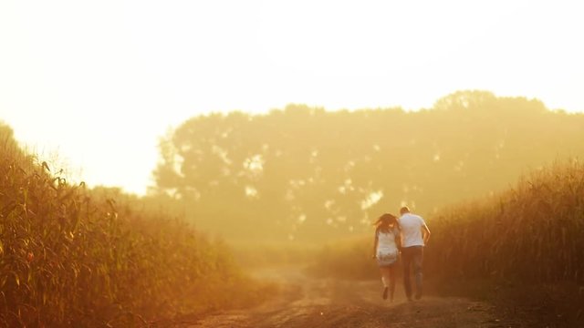 Young couple running along the field
