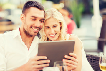 happy couple with tablet pc at restaurant lounge