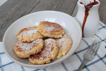 Russian cheese pancakes with chocolate and marshmallow on a light plate and wooden background. sweet delicious Russian food.