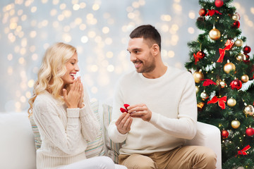 man giving woman engagement ring for christmas