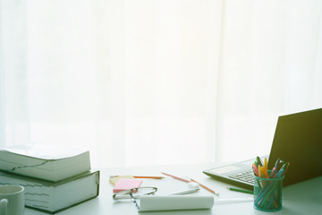 White student's desk table with a lot of things on it.