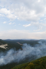 Panoramic view of forest valley with clouds