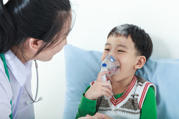 Asian boy having respiratory illness helped by health professional