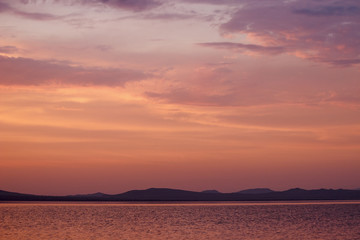 Obraz premium Russia. Khakassia. Sunrise on the Lake Shire. On the horizon, the silhouette of hills and mountains.