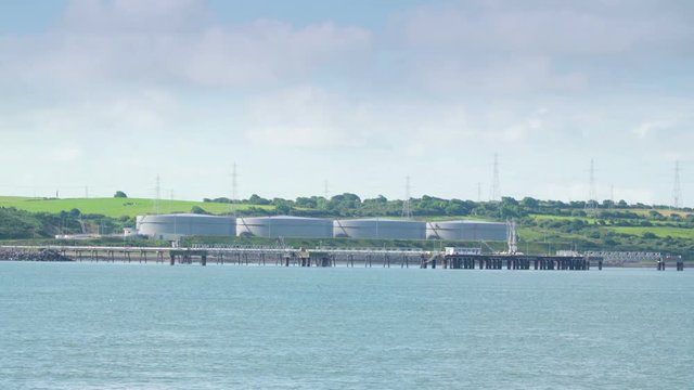 Far away view of the small factory in Killimer Ireland while traveling on the river
