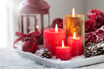 Obraz na płótnie Canvas Christmas candles with fir cones, lantern, christmas decoration and snow, winter or holiday concept, horizontal