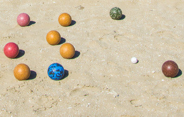 Colored balls for bowling on sand.
