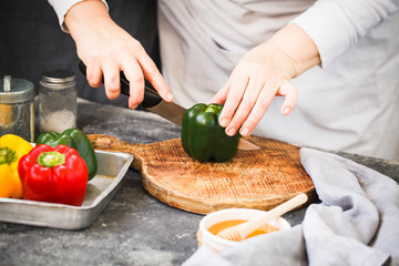 Fresh green pepper. Chef cut green pepper with knife on a cutting board.