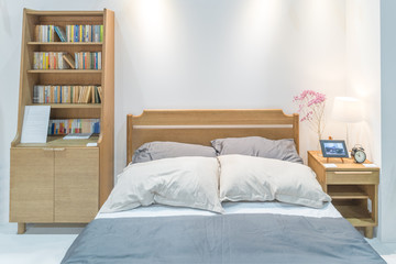 Modern bedroom interior with wooden bed and bookshelf in bedroom