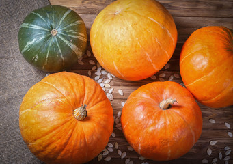 Pumpkins and seeds on a wooden table.
