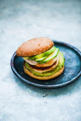 Gourmet hamburger. Avocado chicken barbecue patties gourmet gourmet hamburger on blue plate. copy space.