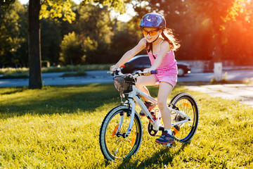 Fototapeta premium happy child girl riding bicycle in summer sunset