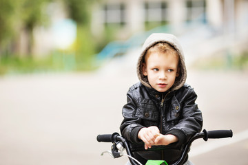 portrait of adorable little urban boy wearing black leather jack