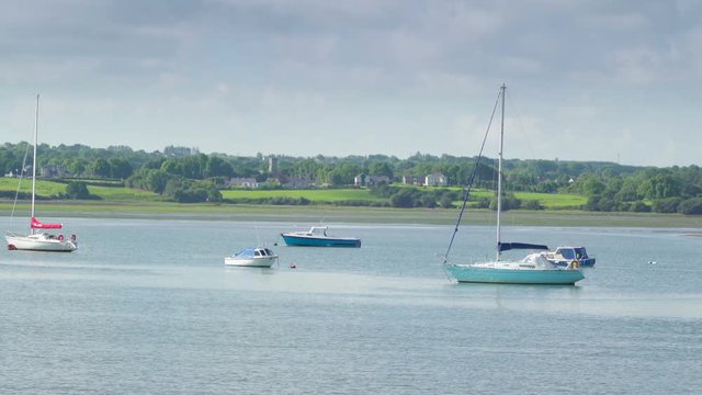 Small boats floating in the river in Tarbert Ireland there are small sailboats on a fine sunny day