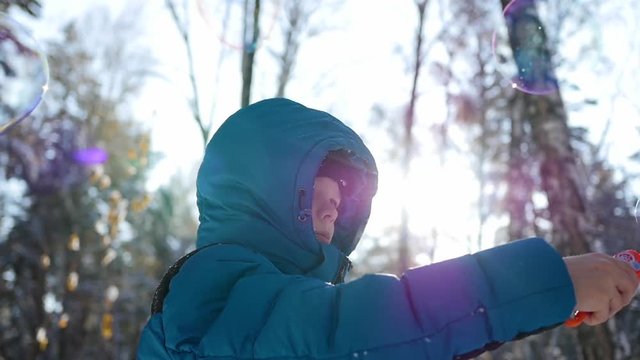 boy makes big soap bubbles in the Park with delight on a Sunny day