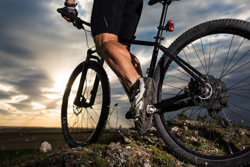 Fototapeta na wymiar Sportive man with bicycle at sunset