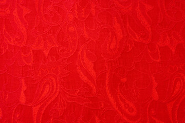 Close-up red beautiful woven ornate paisley ethnic fabric.