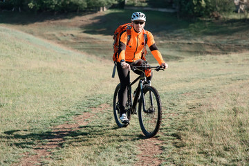 Sportive man with bicycle at sunset