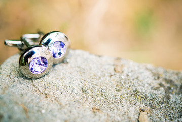 Silver cufflinks on white stone