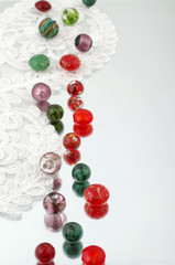 Shimmering glass beads and vintage lace on mirror background 