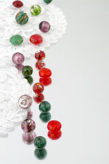 Shimmering glass beads and vintage lace on mirror background 