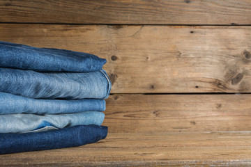 stack of jeans on wooden background
