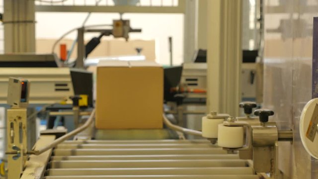 Cardboard boxes travelling along a conveyor belt in a rice factory – 4K