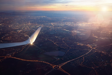 Naklejka premium Widok z okna samolotu lądowania miasta o zachodzie słońca
