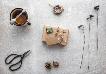 Present, gift top view. Autumn presents dry branches and cup of tea with lemon on concrete background. Gift wrapping ideas. Presents on birthday, christmas, mother's day,