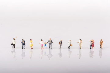 Line of diverse tiny miniature model people