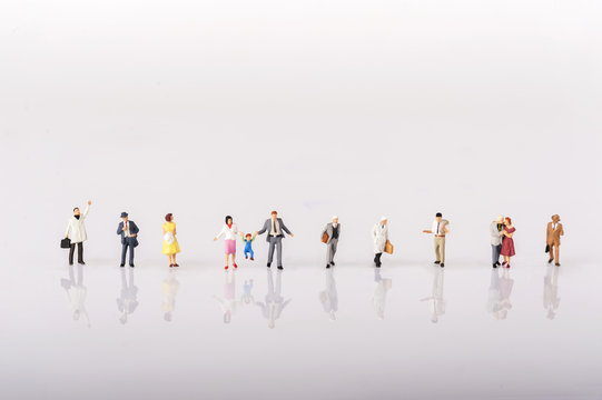 Line of diverse tiny miniature model people