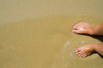 Sea Waves And Girl Feet On Summer Sand Beach. Top view