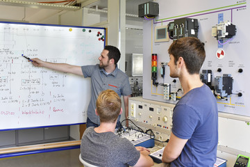 Students looking at technical instructor at whiteboard
