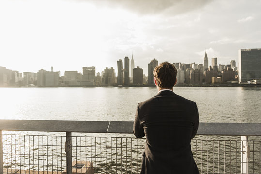 USA, New York City, Back View Of Businessman Looking At Skyline Of Manhattan