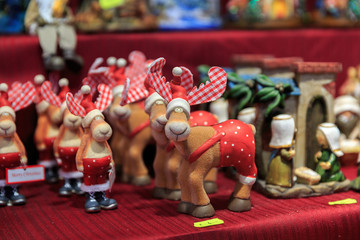 Colorful close up details of christmas fair market. Wooden deer figures decorations for sales