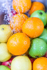 Fresh fruit being washed with tap water in the sink