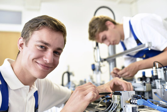 Portrait of smiling student working with pneumatics component parts