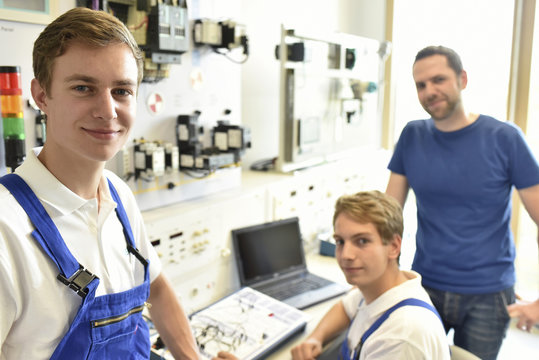 Portrait of smiling students with technical instructor