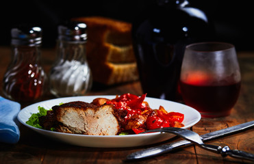 Fried meat with fruit and vegetable garnish and wine